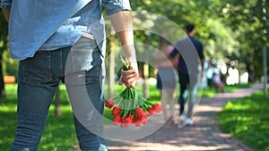 Back view man with flowers watching his girlfriend dating with another male