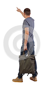 Back view of a man with a green backpack pointing forward
