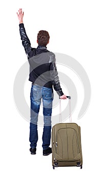 Back view of man with green suitcase greeting waving