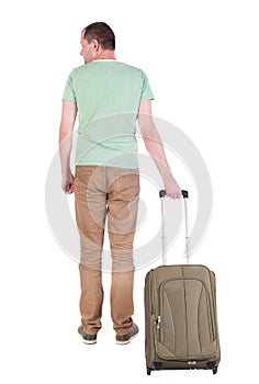 Back view of man with green suitcase looking up