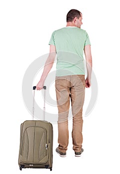 Back view of man with green suitcase looking up