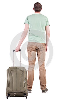 Back view of man with green suitcase looking up