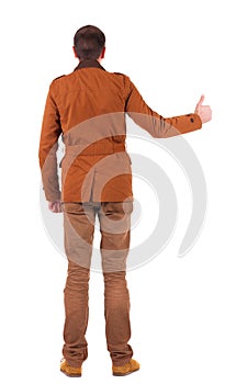 Back view of man in jacket shows thumbs up