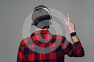 Back View. Man Listening to Music with Headphones