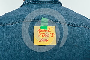 back view of man with note on sticky tape with april fools day lettering on back, april fools day holiday concept