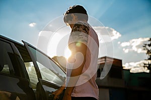 Back view of a man opening a car door