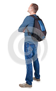 Back view of man with photographic backpack looking up