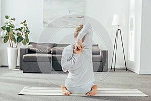 back view of man practicing yoga with hands behind back