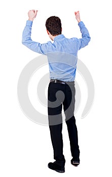 Back view of man. Raised his fist up in victory sign.