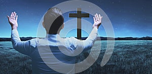 Back view of man raising hand while praying to god