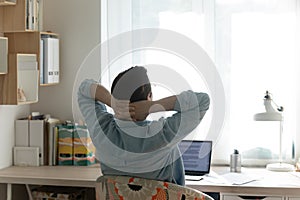 Back view of man relax in chair at home office