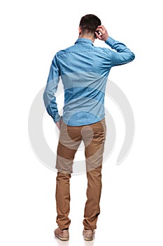 Back view of a man scratching his head and thinking