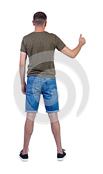 Back view of  man in shorts shows thumbs up