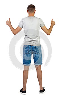 Back view of man in shorts shows thumbs up