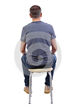 Back view of a man sitting on a chair