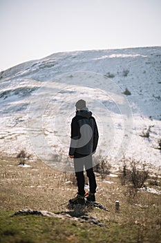 Back view of man standing in front of a snow mountain