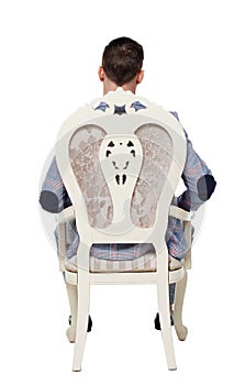 Back view of man in a suit is sitting on an expensive chair