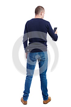 Back view of man in suit talking on mobile phone.