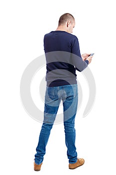 Back view of man in suit talking on mobile phone.