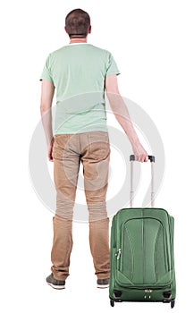 Back view of man with suitcase looking up