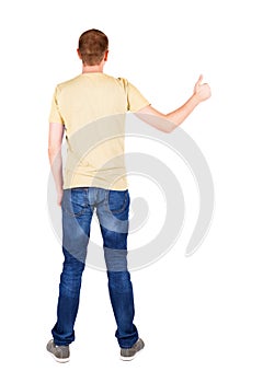 Back view of man in t-shirt. shows thumbs up.