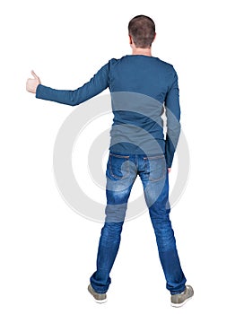 Back view of man in t-shirt. shows thumbs up.
