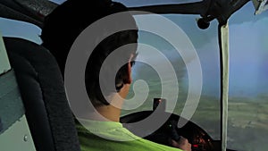 Back view of man training to navigate aircraft in cloudy sky, flight simulator