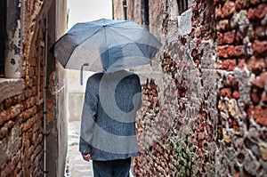 Back view of man walking in the rain.