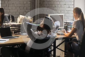 Back view manager relaxing stretching at coworking office