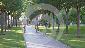 Back view of mature couple cycling at park.