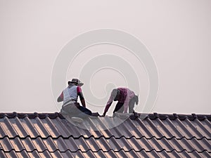 Back view of men working repair on the roof