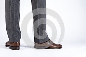 Back View of Mens Legs Wearing Brown penny Loafers. Against White Background