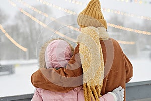 Back View of Mother and Daughter Watching Skating Rink photo