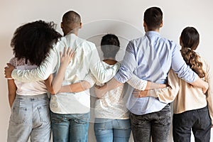 Back view of multiracial friends hug showing unity and support