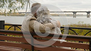Back view old married couple romantic moment man embracing woman on bench in park happy family gray-haired intelligent