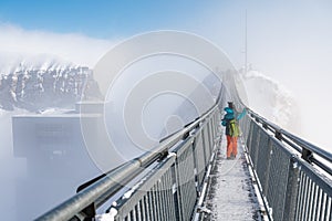 Back view of one kid girl playing with snow on the top of the mountain. Winter vacation with children in Alps. Glacier 3000, les