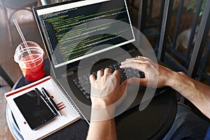 Developer programmer with laptop. Program code and script data on screen. Young freelancer in glasses working on project