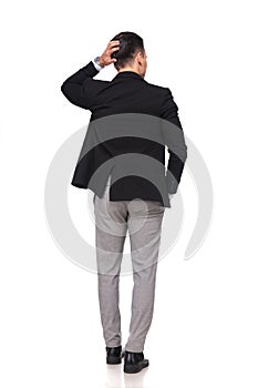 Back view of pensive businessman holding head while standing