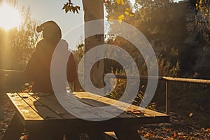 Back view of people enjoying sunset in autumn at the park in outdoor leisure activity and relaxation moment. Wellbeing and contact