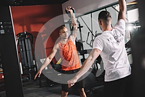 back view of personal trainer lifting