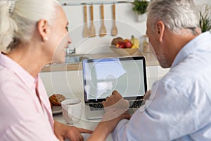 Back view picture of mature loving couple family using laptop