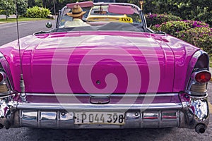 Back view of a pink classic vintage american car in Cuba