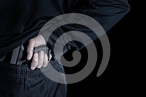 Back view of pistol being pull out of pants by male hand