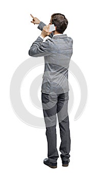 Back view of pointing business man in suit talking on mobile phone