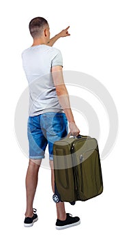 Back view of pointing man with suitcase