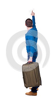 Back view of pointing man with suitcase.