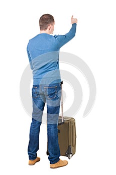 Back view of pointing man with suitcase.