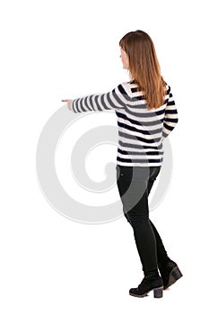 Back view of pointing woman. beautiful girl.