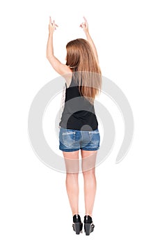 Back view of pointing woman. beautiful redhead girl in shorts.