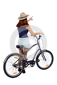 Back view of pointing woman with a bicycle.